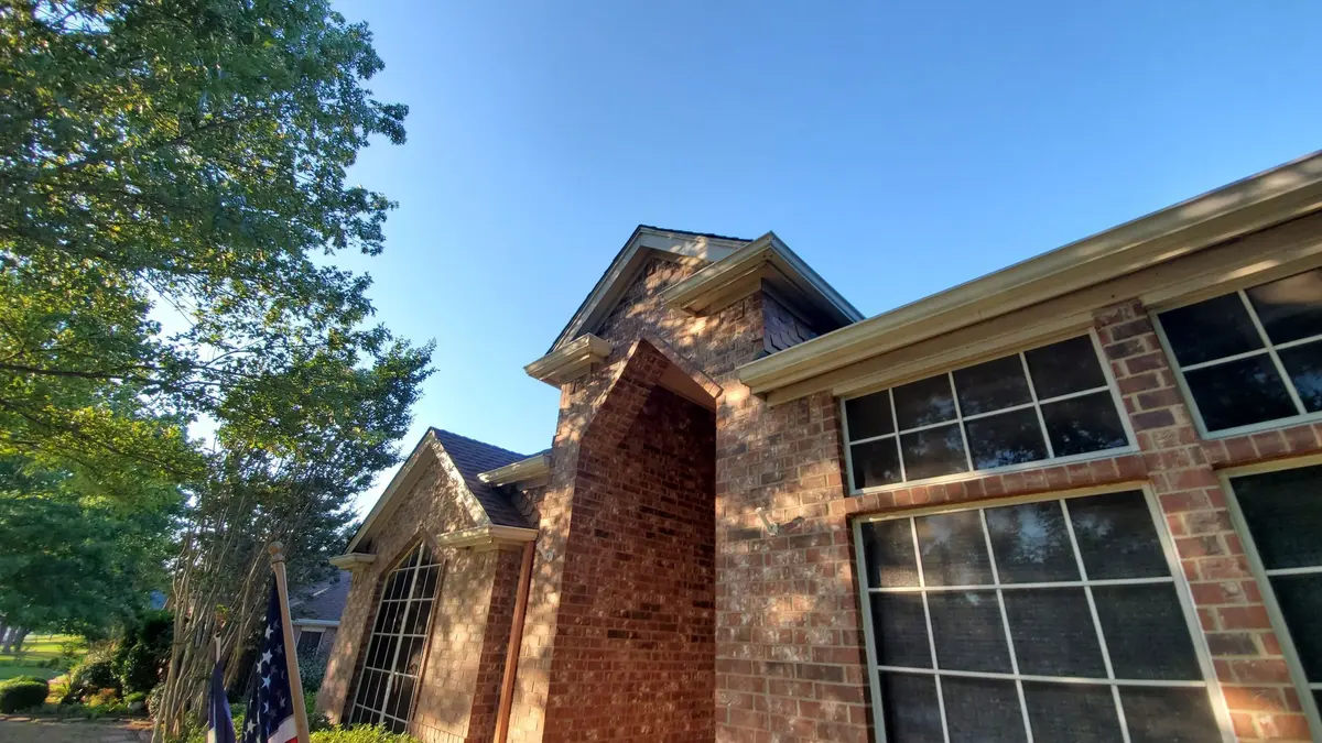 Brick two-story home with a shingle roof in the Fort Worth area