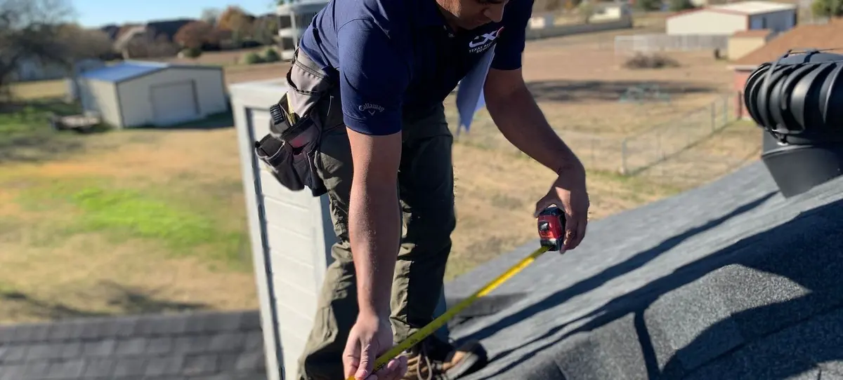 TXR roofer inspecting the edge of a roof in the Texas Hill Country