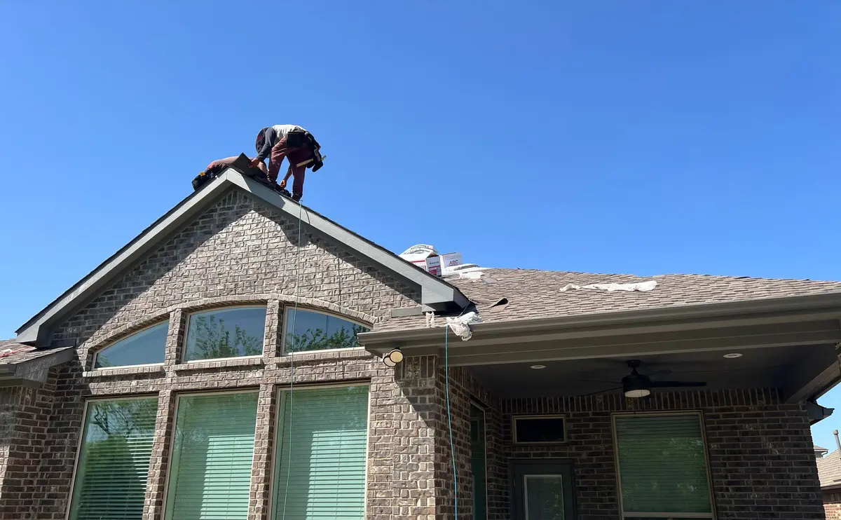TXR roofing crew making repairs on the roof of a brick home in Arlington
