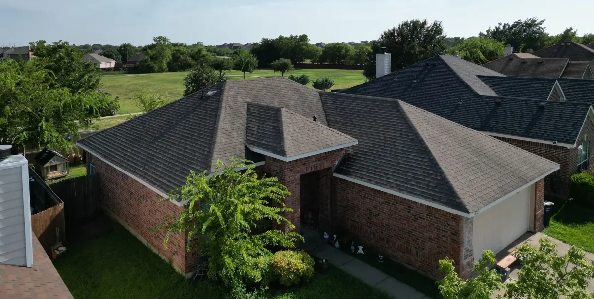 Aerial view of an Arlington brick home with a newly replaced shingle roof by Texas Republic Roofing